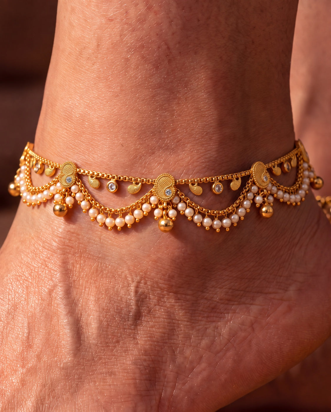 Ava Pearl anklets close-up with textured paisley details, pearl-like bead fringe, clear accents, and bell charms