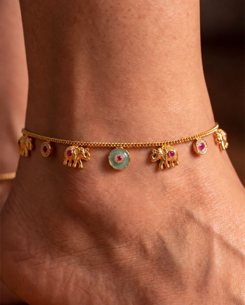 Marigold Bloom anklets close-up with elephant charms, pink round accents, and a raised teal center accent