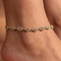 Close-up of Luna Blossom Anklets, gold-tone floral motifs set with clear stones