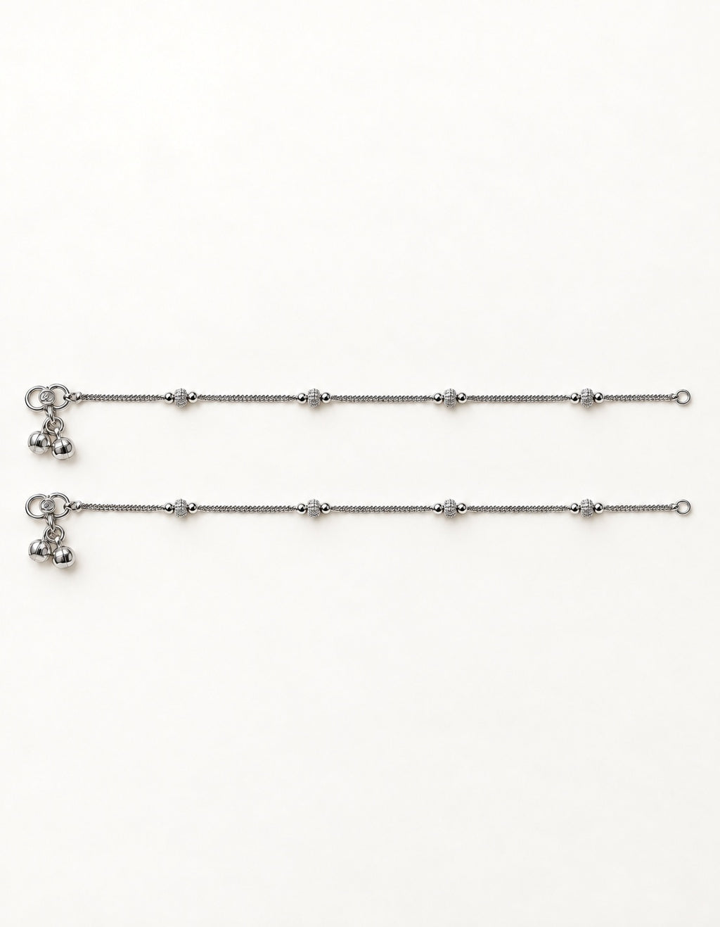 Pair of Luma Frost silver-tone anklets laid flat with four small textured bead stations on each anklet