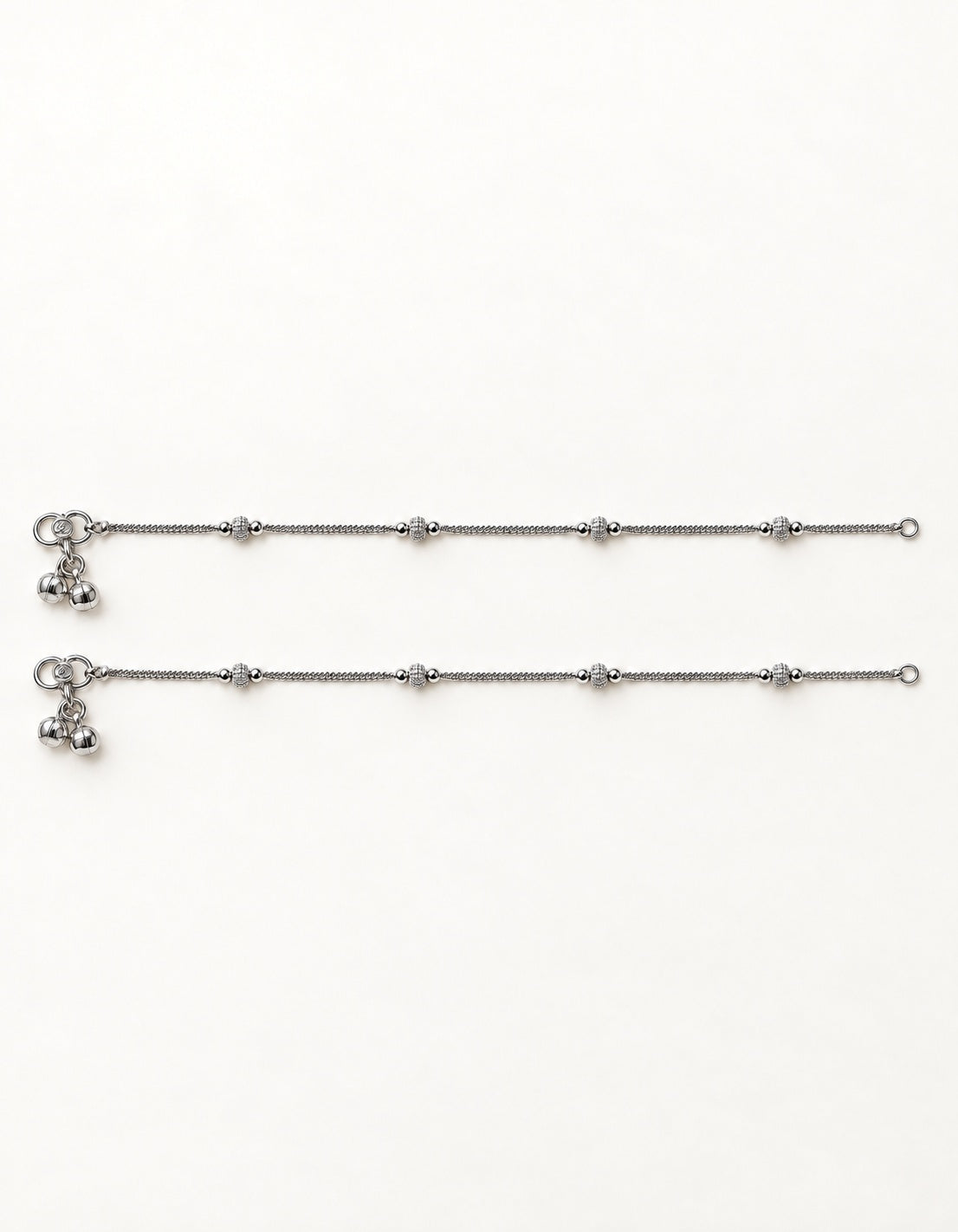 Pair of Luma Frost silver-tone anklets laid flat with four small textured bead stations on each anklet
