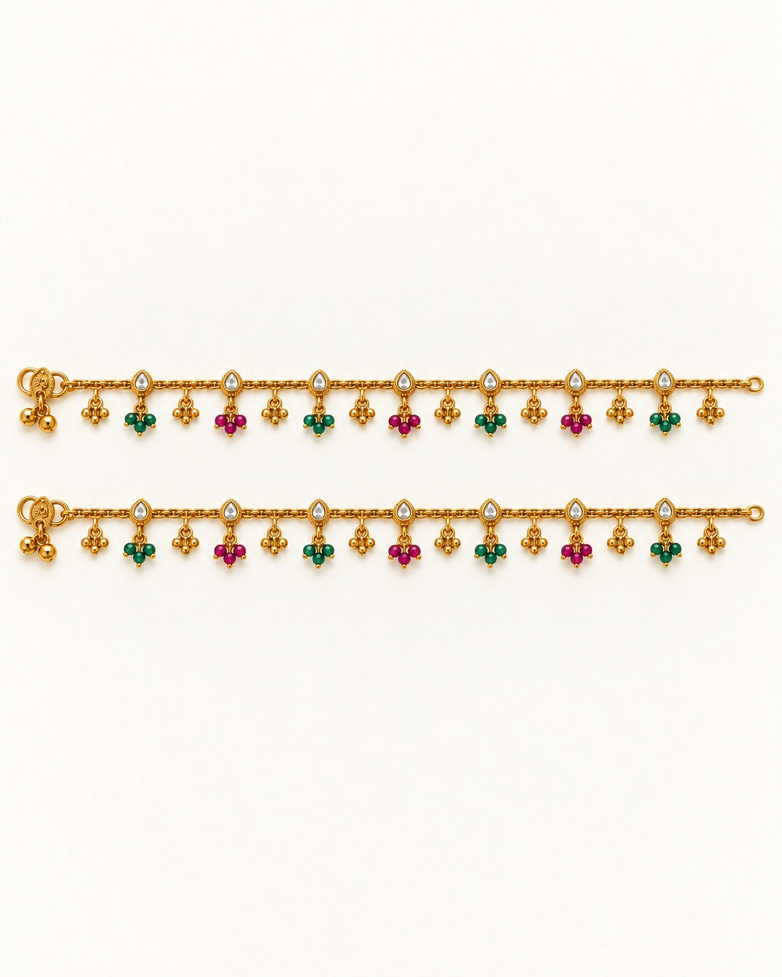 Pair of Coral Bloom gold-tone anklets laid flat with clear pear-shaped accents and alternating green and magenta bead drops