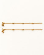 Pair of Luma Glow gold-tone anklets laid flat with three textured bead stations on each anklet