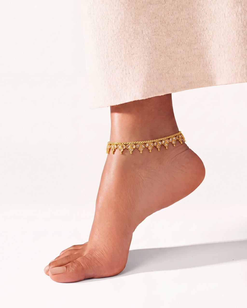 Vera gold-tone anklet worn on a raised ankle