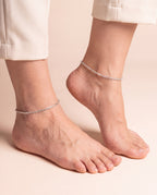 Pair of Gilded Braid silver-tone anklets worn on both ankles