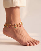 Coral Bloom gold-tone anklet worn on one ankle showing clear pear-shaped accents and green and magenta bead drops