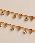 Close pair detail of matching Mira Dewdrop Anklets, gold-tone chain with three-bell clusters, clear pear stones, and pink accents