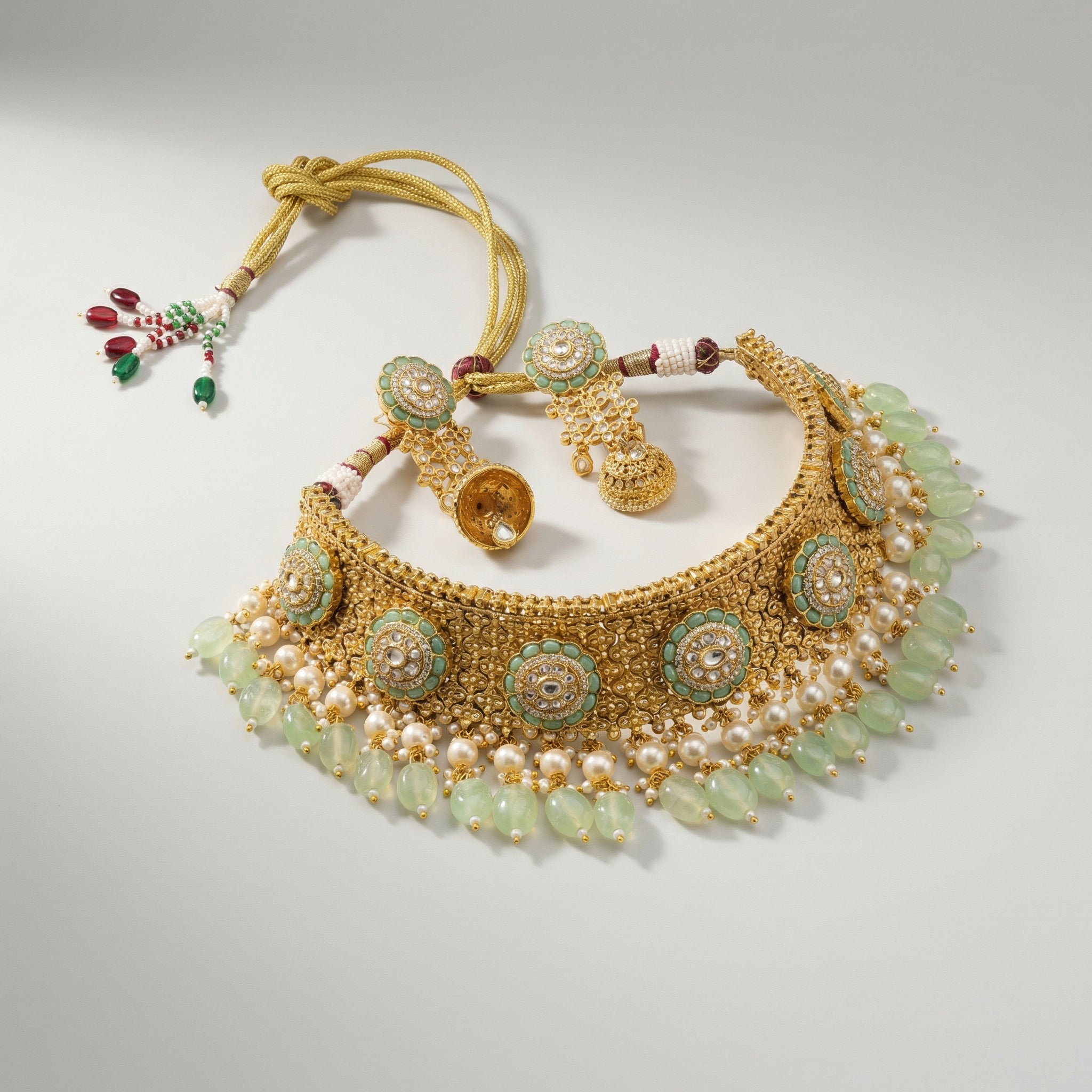Studio flatlay of the gold-tone mint choker with matching earrings