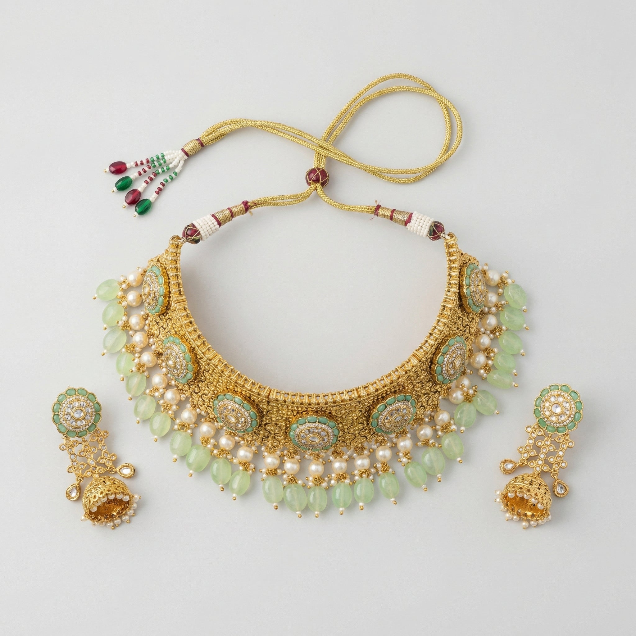 Detail flatlay of the gold-tone mint choker and matching earrings with mint accents