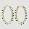 Emerald Pearl Anklets pair of gold-tone pearl payals with green drops and clear stones on gray background