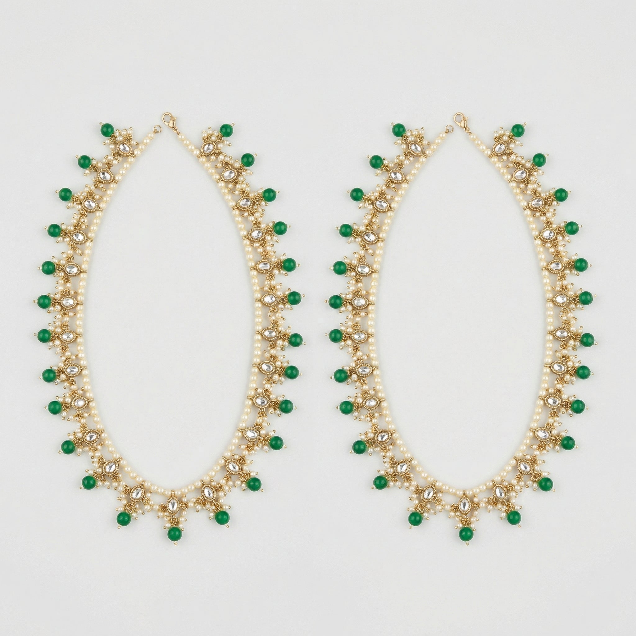 Emerald Pearl Anklets pair of gold-tone pearl payals with green drops and clear stones on gray background