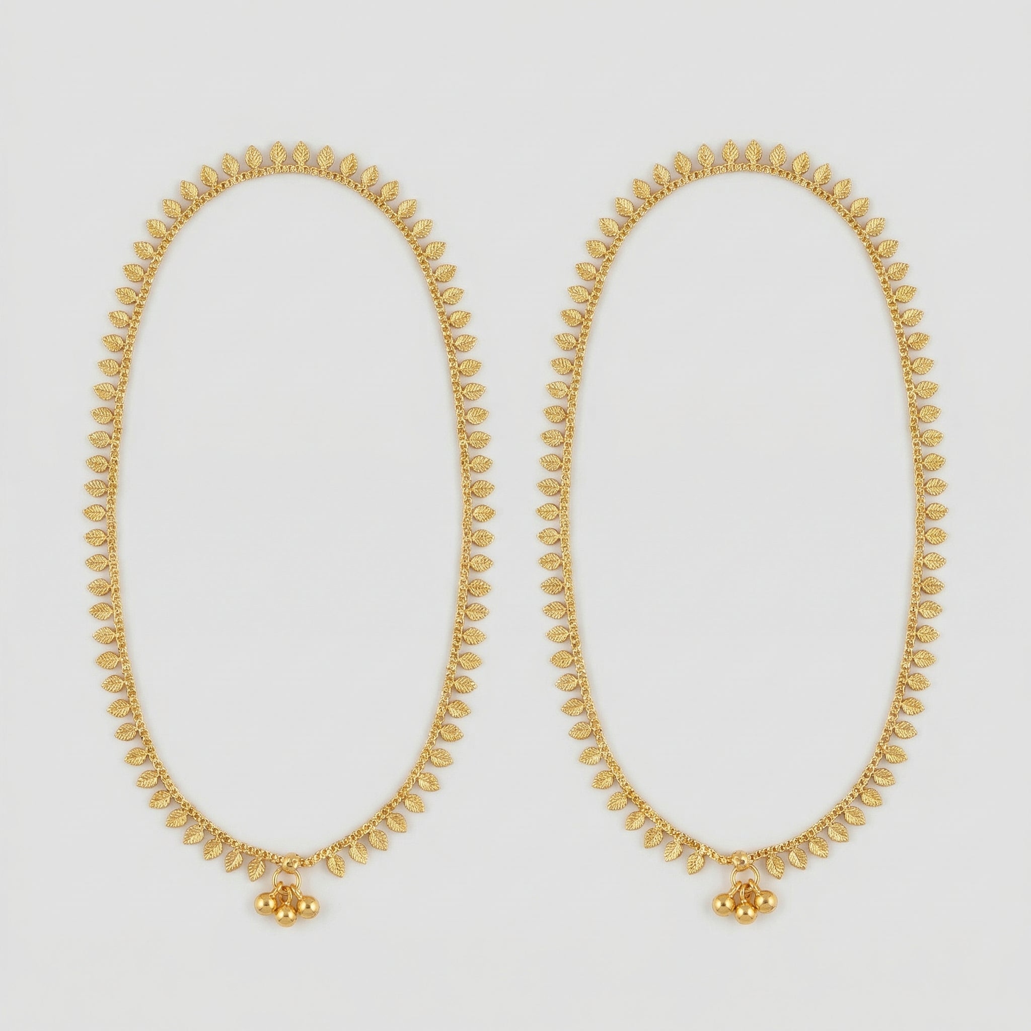 Golden Leaf Anklets pair of gold-tone leaf fringe payals with triple bead accent on gray background