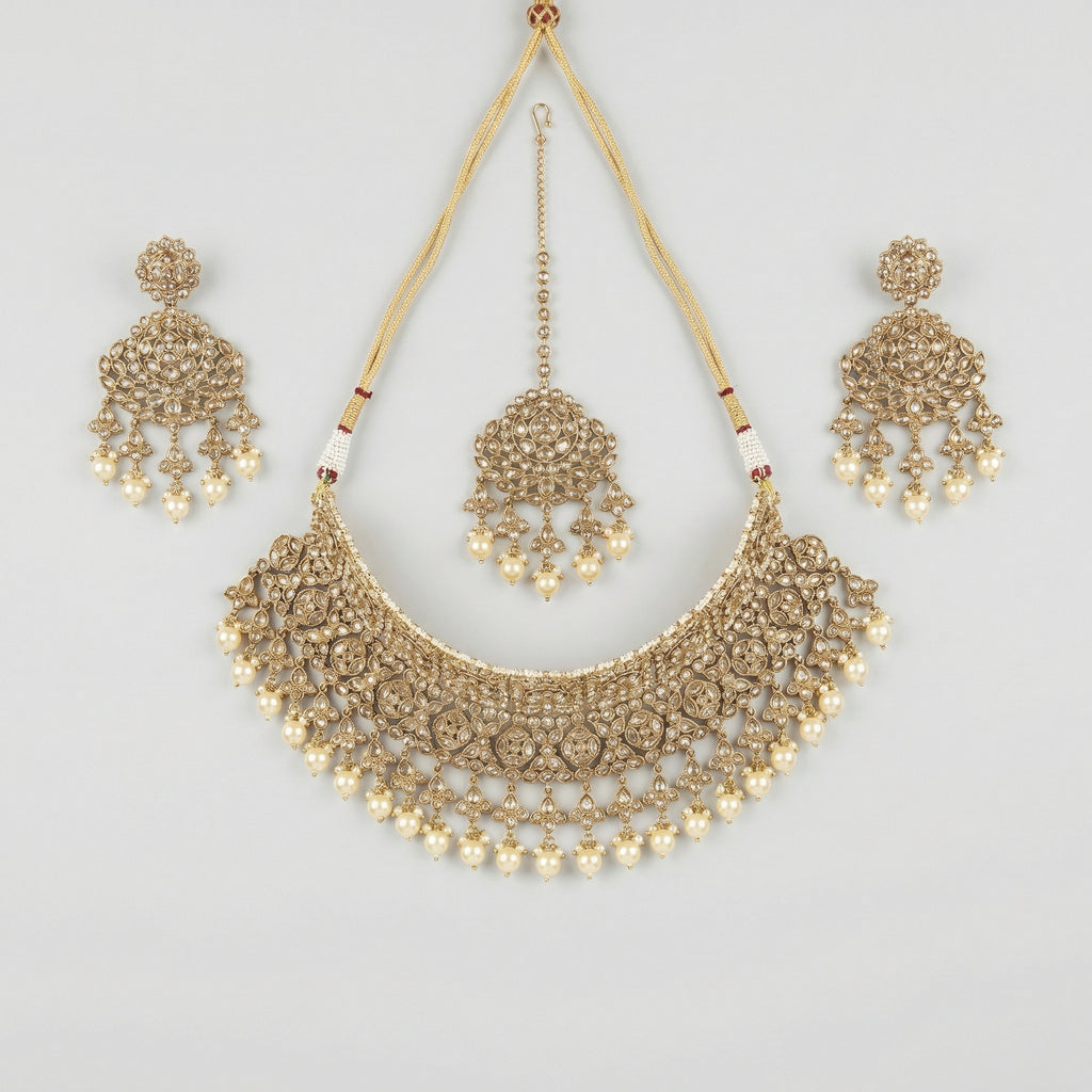 Regal Pearl Necklace Set gold polki bib with pearl drops, chandelier earrings, and maang tikka on gray background