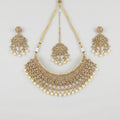 Regal Pearl Necklace Set gold polki bib with pearl drops, chandelier earrings, and maang tikka on gray background