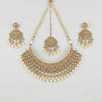 Regal Pearl Necklace Set gold polki bib with pearl drops, chandelier earrings, and maang tikka on gray background