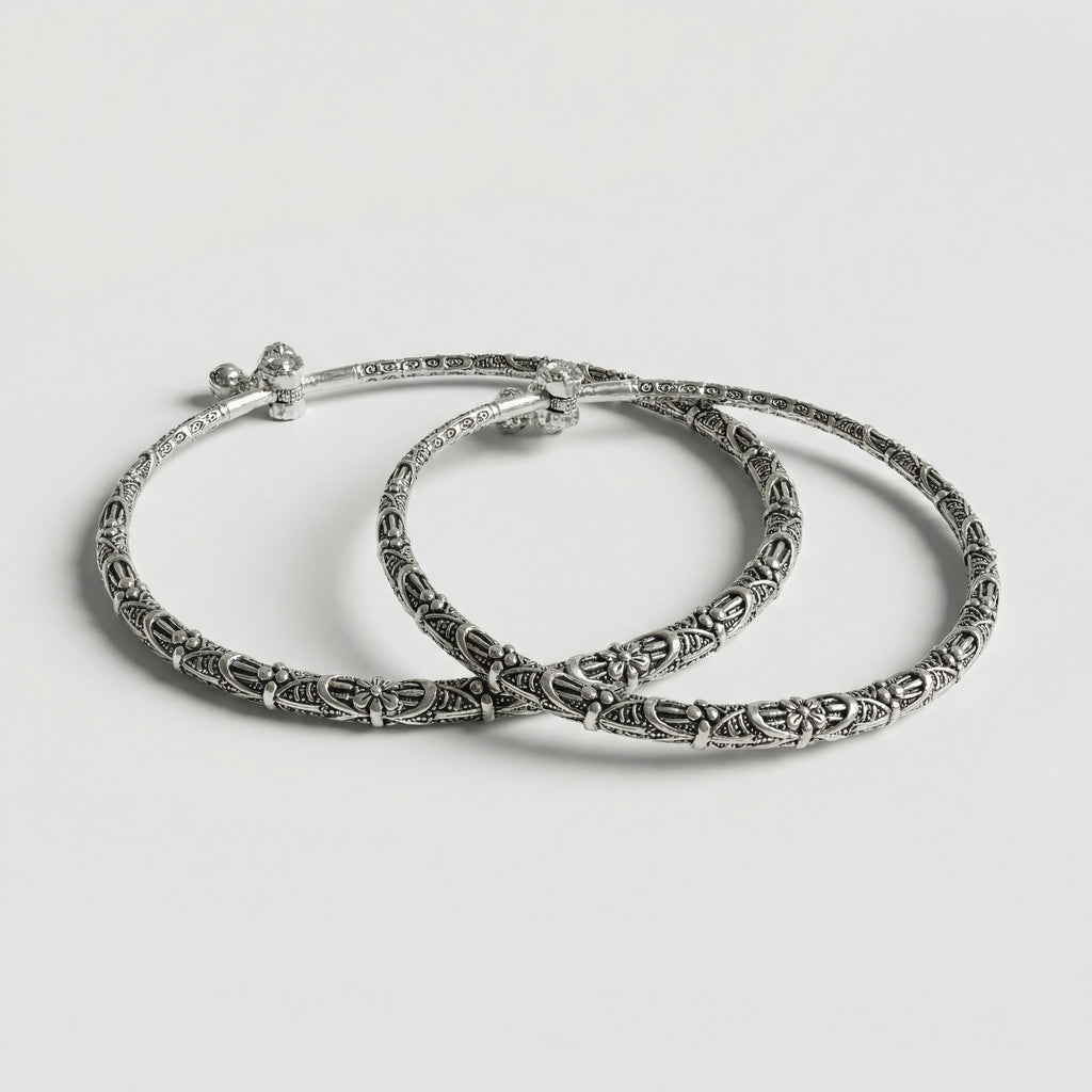 Oxidized Floral Anklets pair of antique silver rigid kada payals with floral filigree on gray background