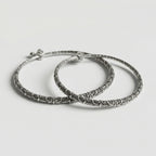 Oxidized Floral Anklets pair of antique silver rigid kada payals with floral filigree on gray background