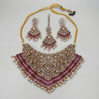 Meera Ruby Radiance Set silver bib necklace with pink stones, chandelier earrings, and maang tikka on gray background