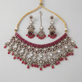 Regal Crimson Choker Set antique silver choker with jhumka earrings and maang tikka on gray background