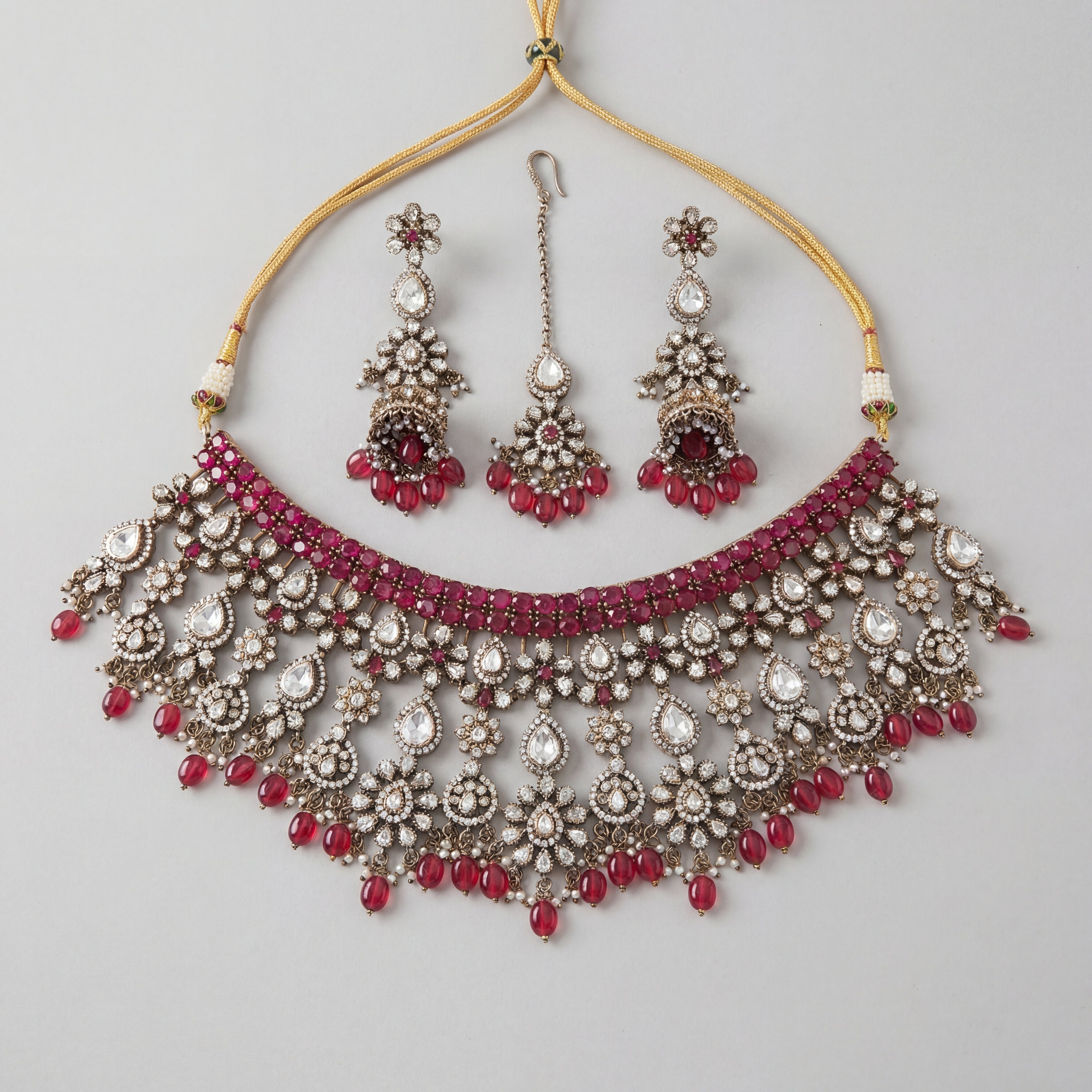 Regal Crimson Choker Set antique silver choker with jhumka earrings and maang tikka on gray background