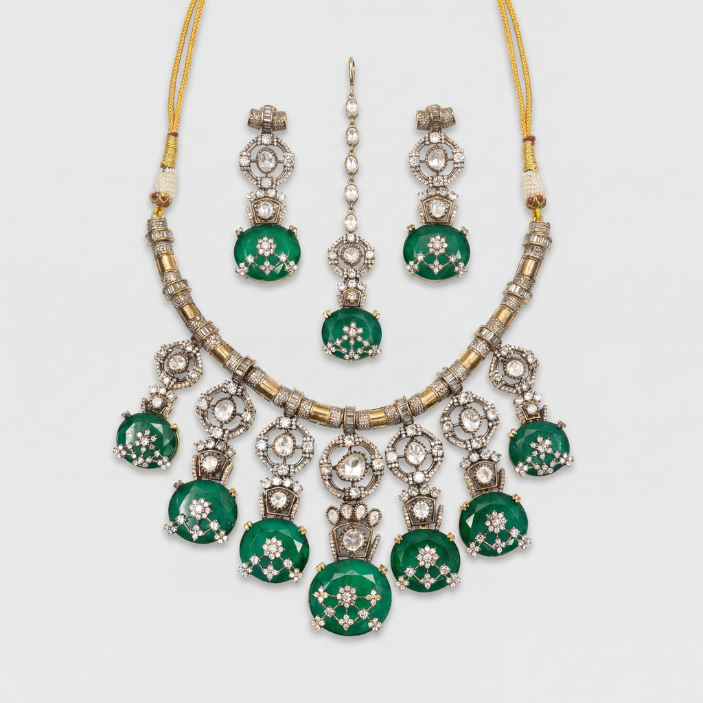 Zaira Emerald Necklace Set silver collar necklace with emerald pendants, earrings, and maang tikka on gray background