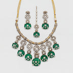 Zaira Emerald Necklace Set silver collar necklace with emerald pendants, earrings, and maang tikka on gray background