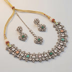 Amara Multi-Stone Choker Set silver polki collar with green pink and peach stones, earrings, and maang tikka on gray background