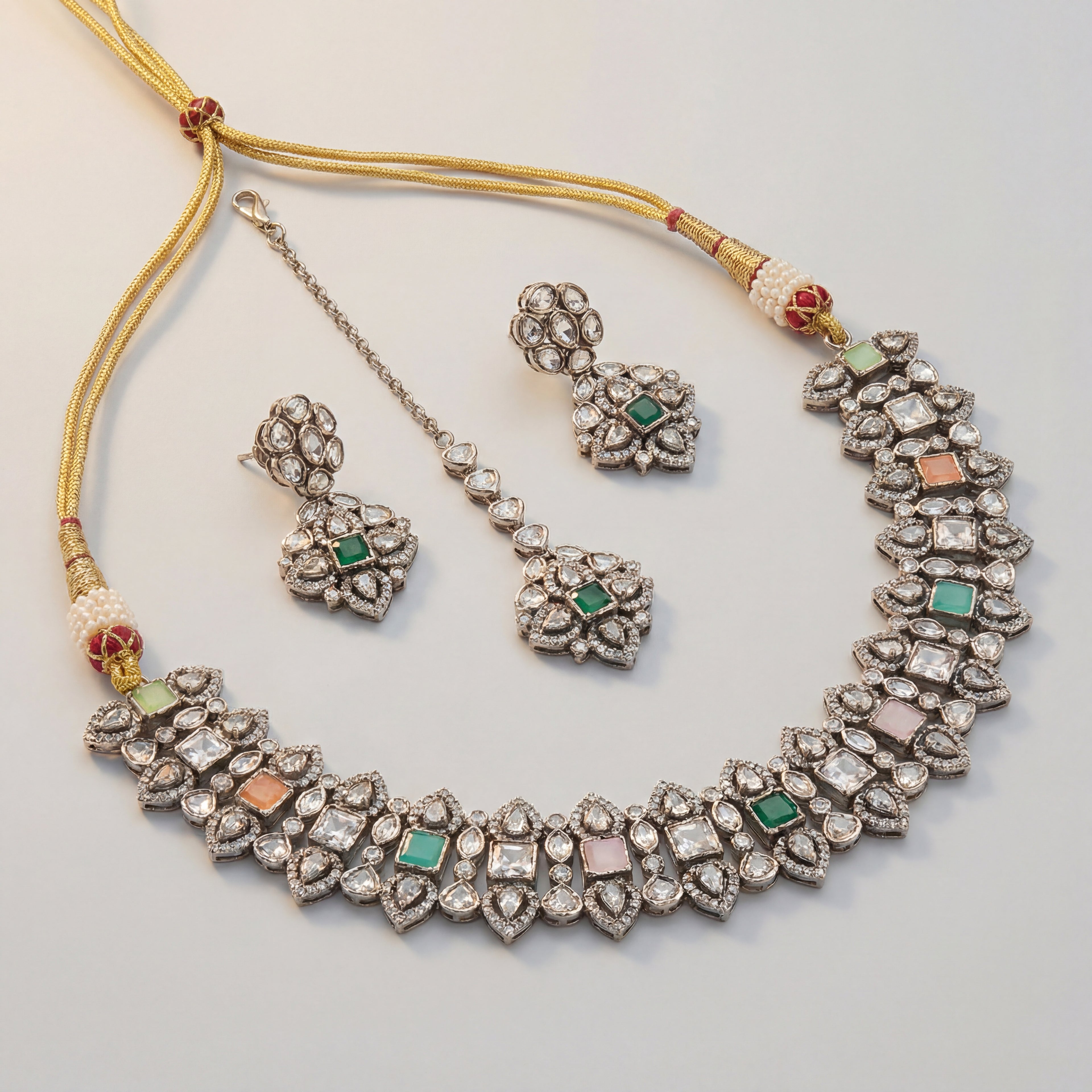 Amara Multi-Stone Choker Set silver polki collar with green pink and peach stones, earrings, and maang tikka on gray background