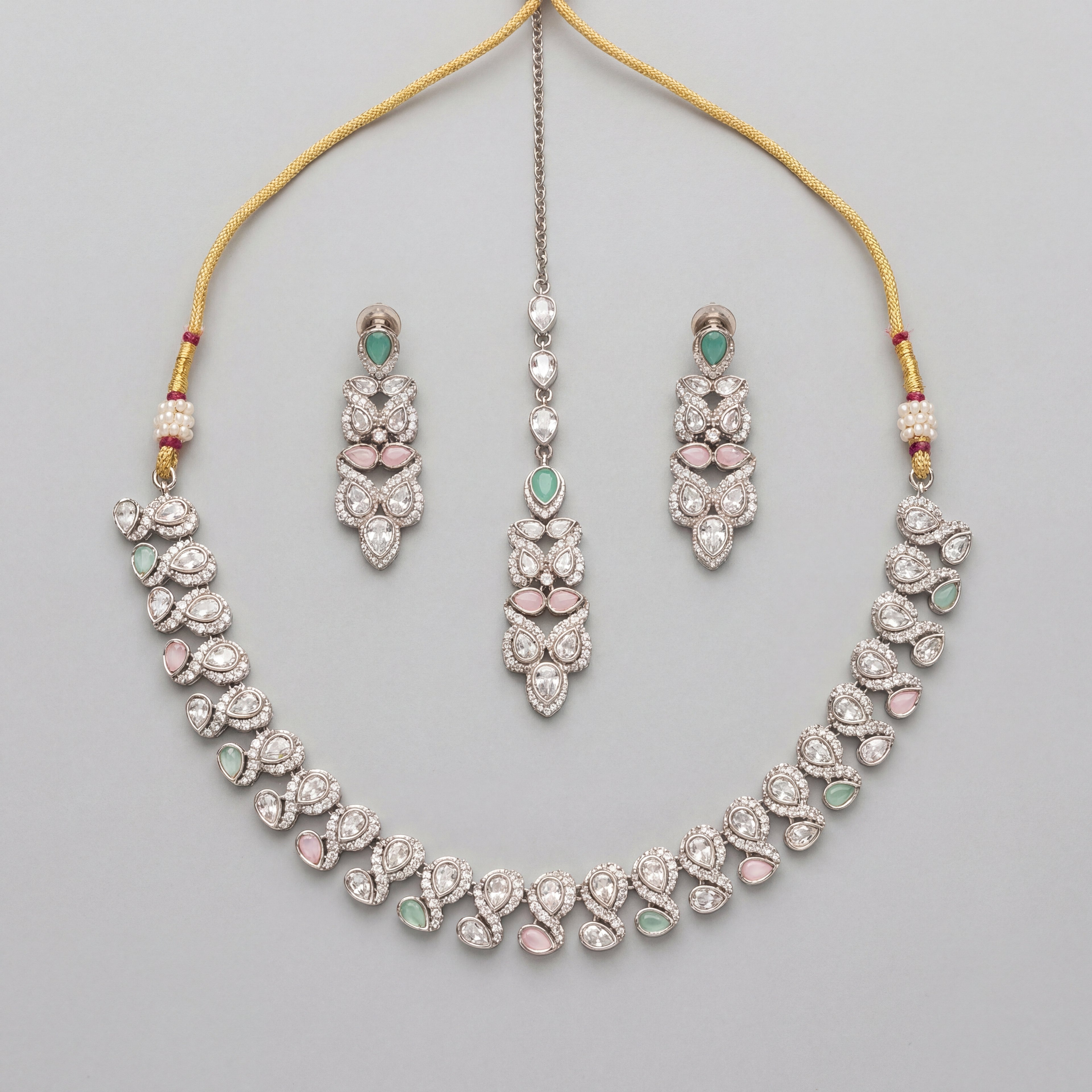 Aria Pastel Necklace Set silver collar necklace with mint and pink stones, earrings, and maang tikka on gray background