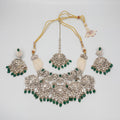 Inara Emerald Necklace Set silver bib necklace with green bead fringe, chandelier earrings, and maang tikka on gray background