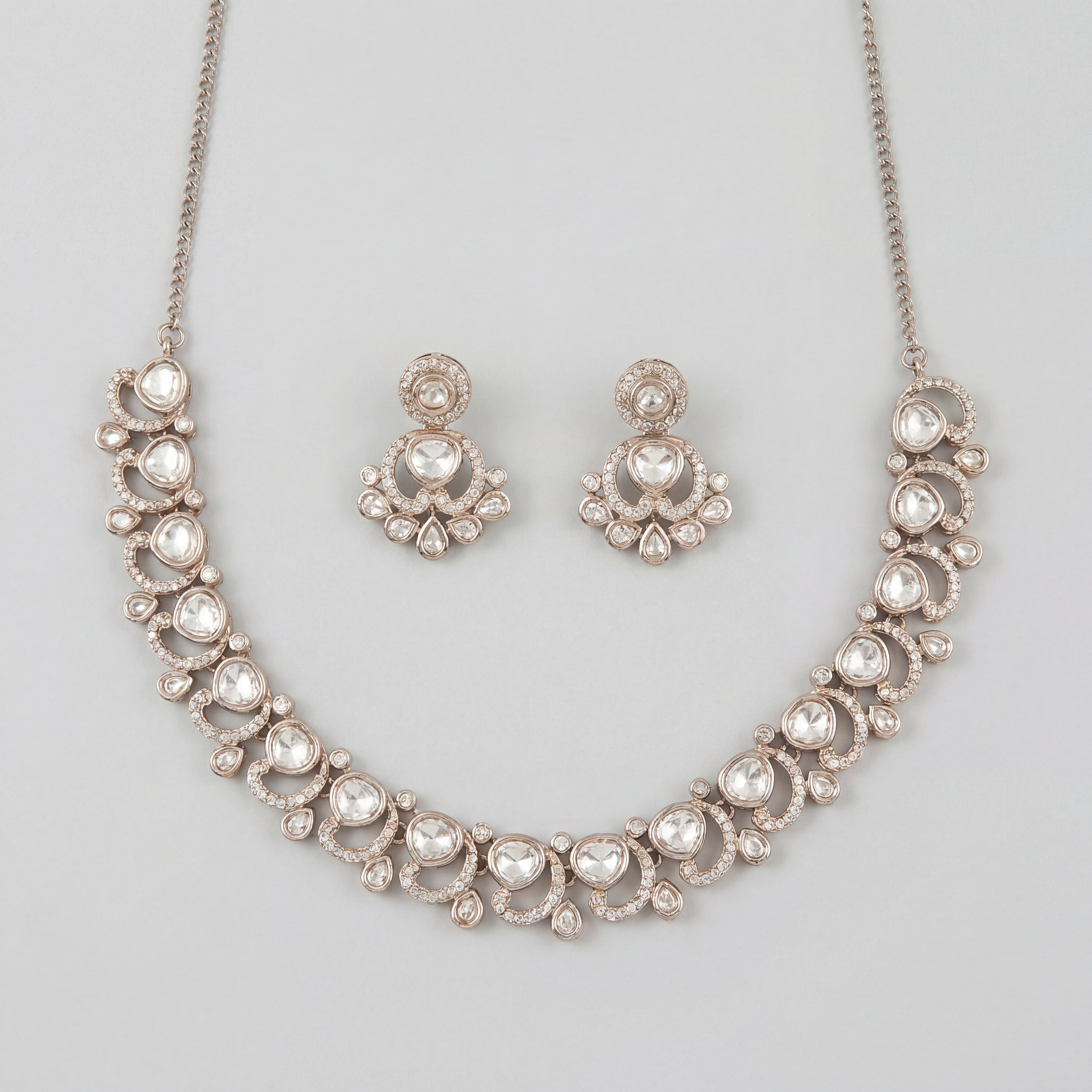 Aria Crystal Necklace Set silver polki collar necklace with matching chandelier drop earrings on gray background