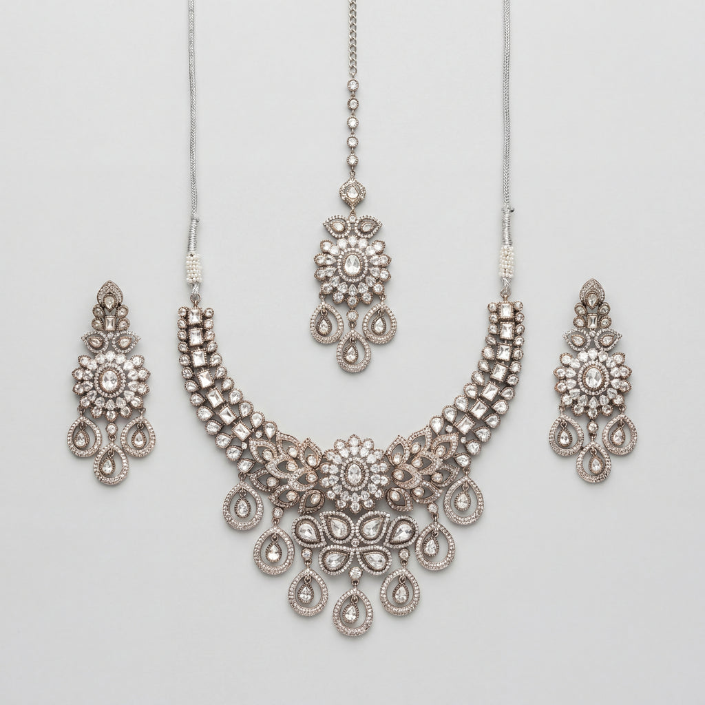 Aria Silver Necklace Set antique silver bib collar with chandelier earrings and maang tikka on gray background