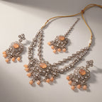 Aria Peach Necklace Set detail showing peach cabochon center, crystal floral border, and teardrop bead fringe