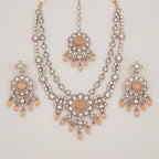 Aria Peach Necklace Set silver bib necklace with peach stones, drop earrings, and maang tikka on gray background
