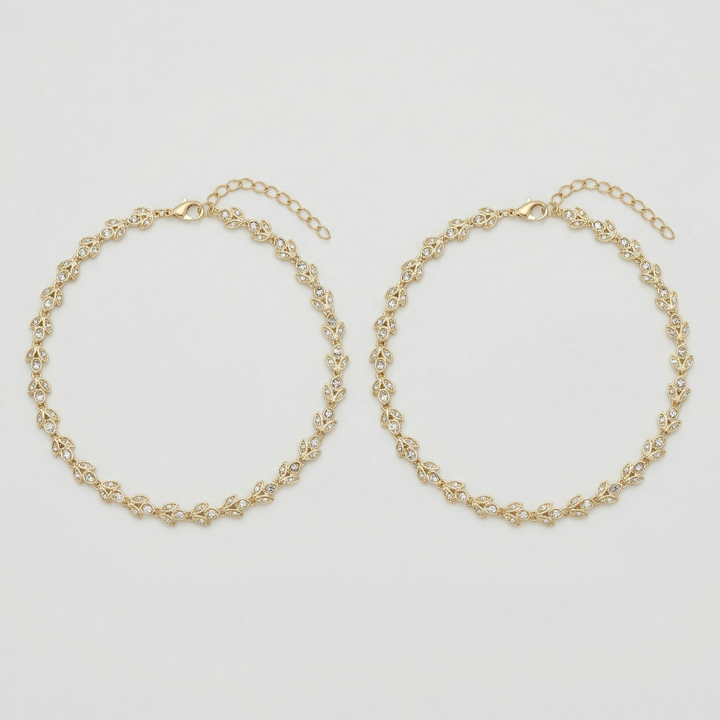 Gilded Leaf Crystal Anklets pair of gold-tone pavé leaf payals on gray background