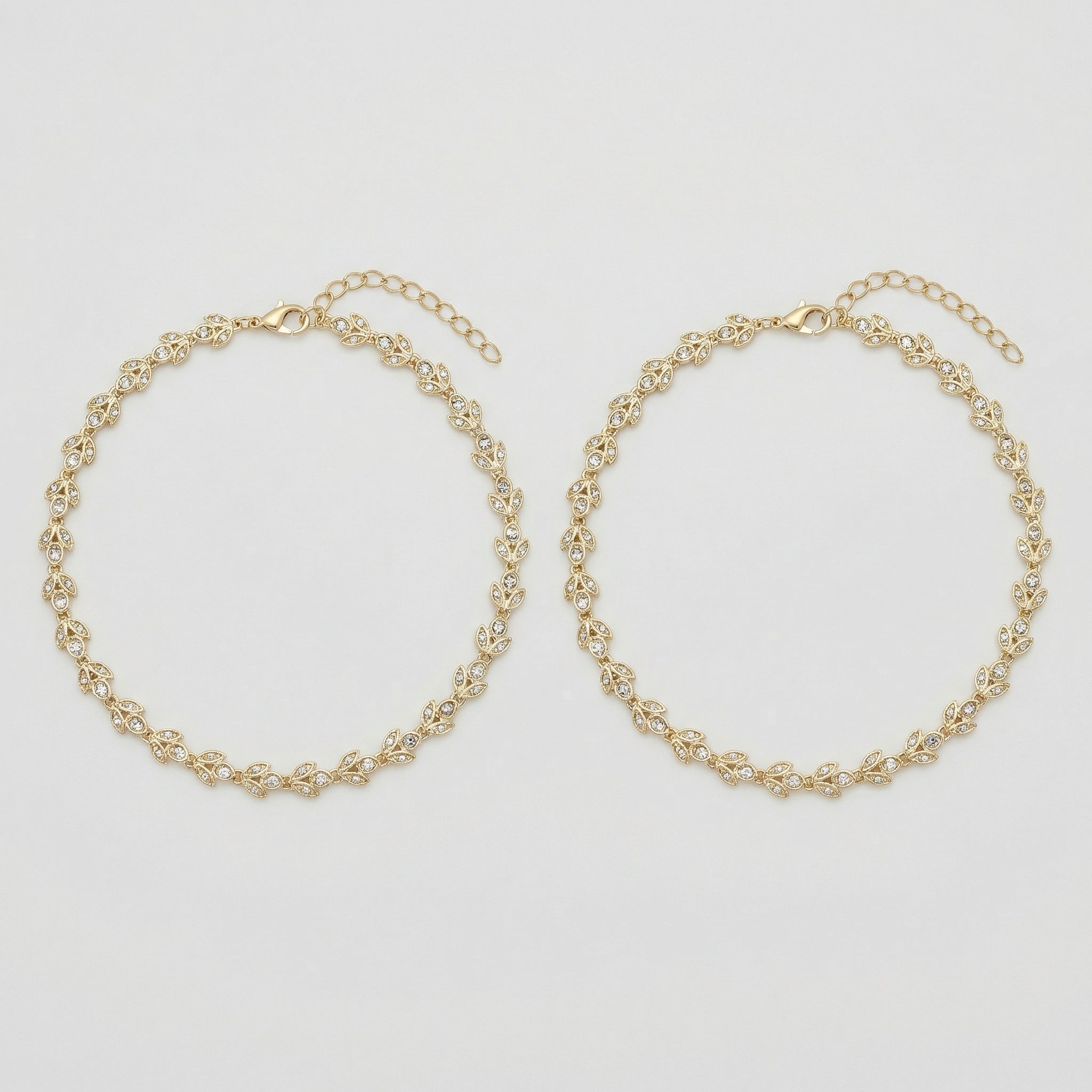 Gilded Leaf Crystal Anklets pair of gold-tone pavé leaf payals on gray background