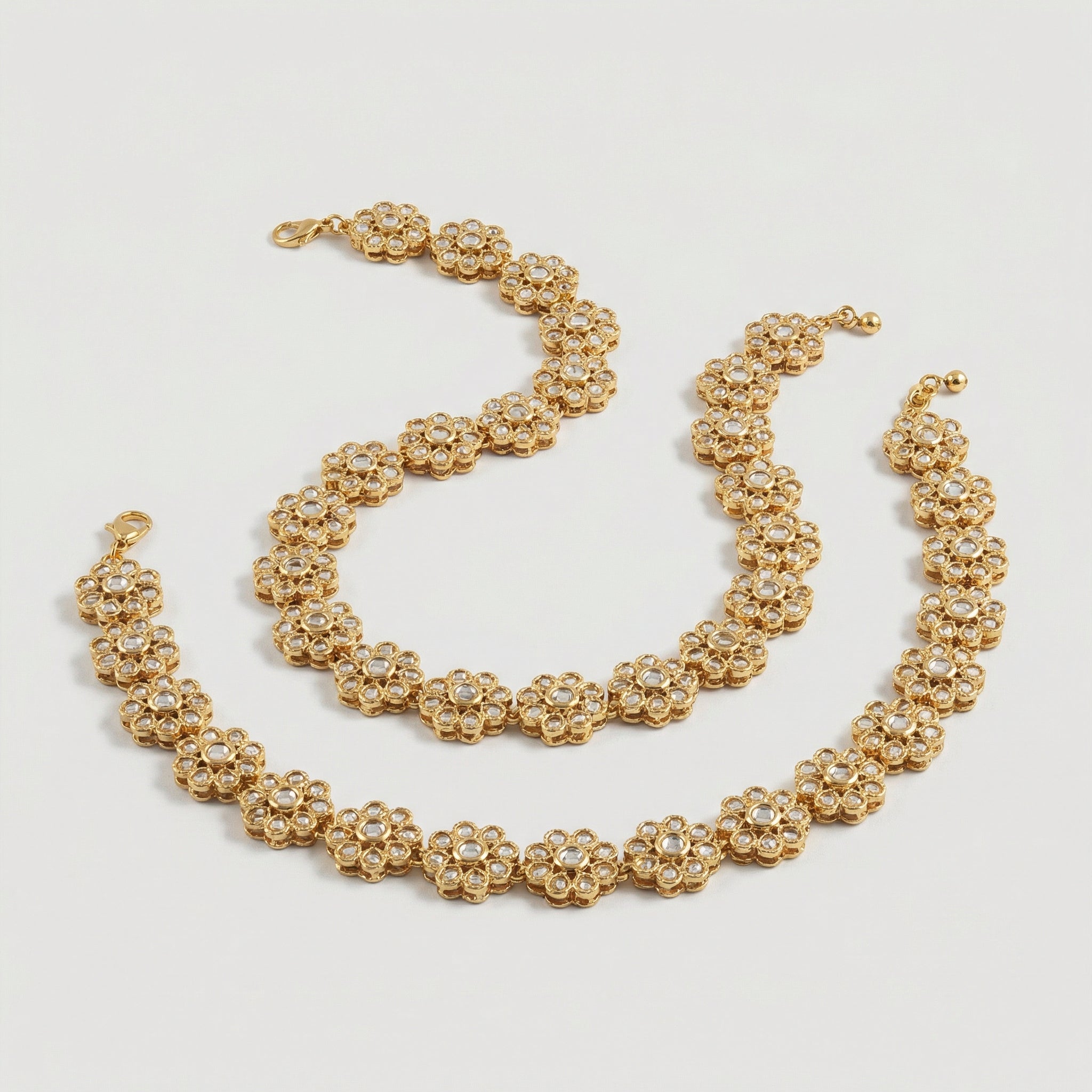 Gilded Blossom Anklets detail showing six-petal flower links and pavé centers