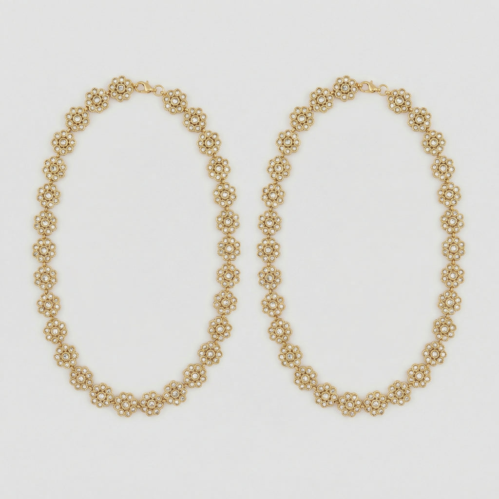 Gilded Blossom Anklets pair of gold-tone floral crystal payals on gray background