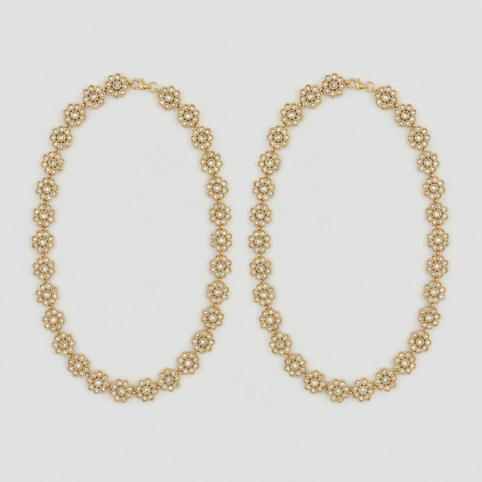 Gilded Blossom Anklets pair of gold-tone floral crystal payals on gray background