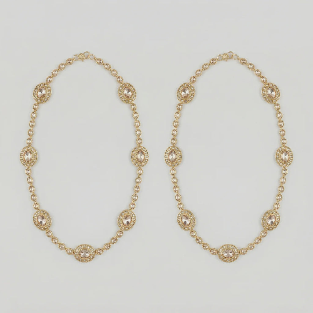 Gilded Kundan Anklets pair of gold-tone halo oval payals with pavé crystal chain on gray background
