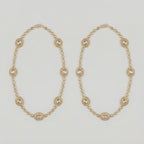 Gilded Kundan Anklets pair of gold-tone halo oval payals with pavé crystal chain on gray background