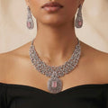 Studio flatlay of the silver-tone rose quartz necklace with matching earrings