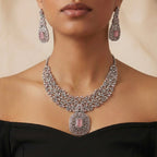 Studio flatlay of the silver-tone rose quartz necklace with matching earrings