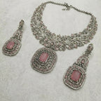 Detail flatlay of the silver-tone rose quartz necklace and matching earrings with blush pink stones