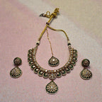 Close-up flatlay of Emerald Kundan Necklace Set necklace and matching earrings