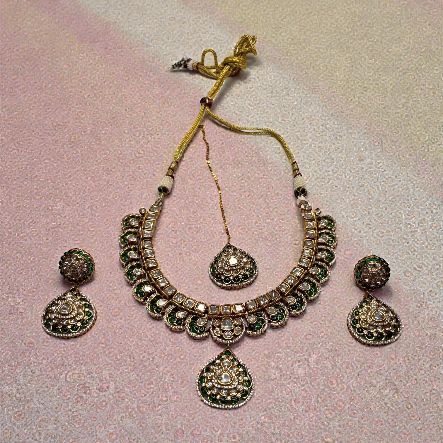 Close-up flatlay of Emerald Kundan Necklace Set necklace and matching earrings