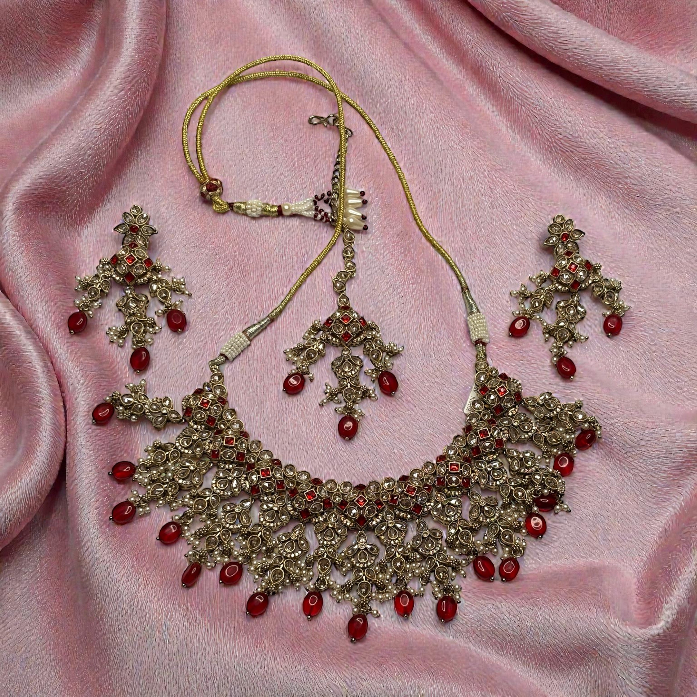 Detail flatlay of the ruby cascade necklace set, highlighting the stonework and earrings.