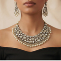 Studio flatlay of the white stone necklace set with matching earrings.