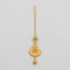 Priya Ruby Tikka matte gold maang tikka with ruby-pink stones on gray background