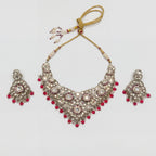 Aira Ruby Necklace Set silver kundan bib collar with ruby-red bead fringe and matching drop earrings on gray background